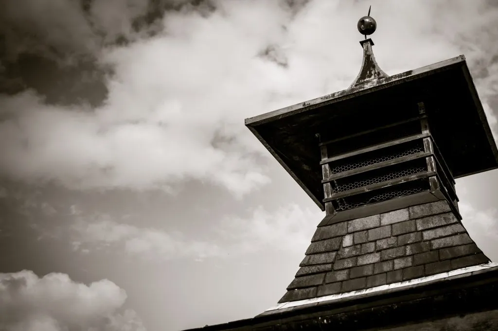 The pagoda-style kiln roof against a moody Dartmoor sky